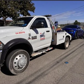 Guardian tow truck with a Charger in tow